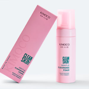 Po środku różowe pudełko oparte o różową butelkę z pompką kosmetyku Clean Skin Gentle Cleansing Foam, na białym tle.