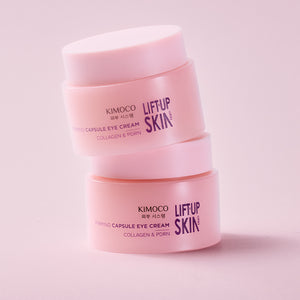 dwa różowe słoiczki "Kimoco Lift-Up Skin Firming Capsule Eye Cream" ustawione jeden na drugim, na jasnoróżowym tle.