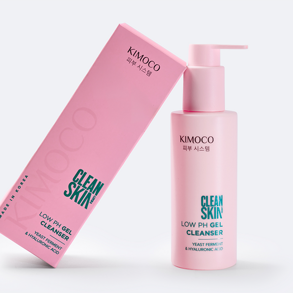 Po środku różowe pudełko oparte o różową butelkę z pompką kosmetyku Clean Skin Low pH Gel Cleanser, na białym tle.