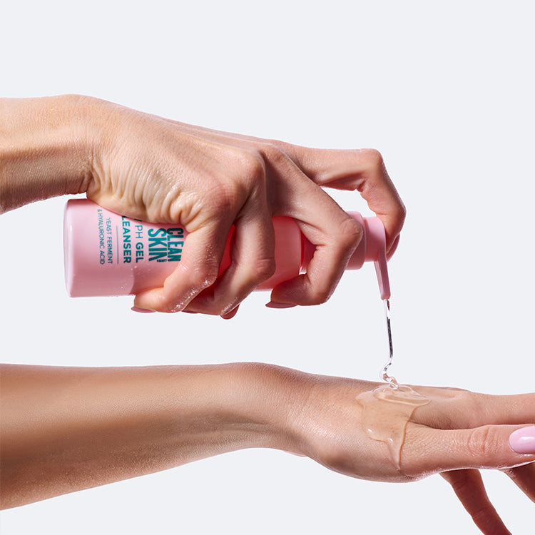 U góry dłoń trzymająca różową butelkę z dozownikiem "Clean Skin PH Gel Cleanser", z pompki wypływa przezroczysty żel; u dołu wyciągnięte przedramię i dłoń z nałożonym na niej żelem, na białym tle.