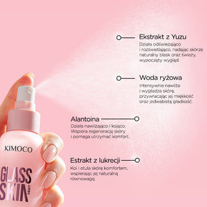 Z lewej dłoń trzymająca różową butelkę z rozpylaczem Kimoco Glass Skin, z widocznym rozpylonym mgiełką produktu, u góry z prawej opis składnika Ekstrakt z Yuzu rozświetlającego skórę, poniżej opis składnika Woda ryżowa nawilżająca i wygładzająca, u dołu opis składnika Alantoina kojącego skórę oraz Ekstrakt z lukrecji łagodzącego, na różowym tle.